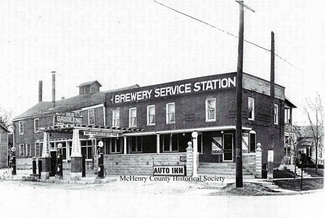 This photo is of the Brewery Service Station (today the McHenry Brewing Company), corner of Pearl and Green Streets, during Prohibition.
During prohibition, the lower floor of the brick building was an office used for a petroleum distribution business and gasoline pumps were placed on the Pearl Street side of the brewery. In 1921, Michael Worts opened an ice cream parlor and light lunch establishment there and the upper floor was converted into living quarters. For a few years in the 1920s, the frame building was occupied by an auto repair shop operated by George Phalin. From 1928-1931, it was used as an office and warehouse for Patsy Boley&rsquo;s malt extract distribution business. Breweries had to be careful not to be found providing both malt extract and yeast, because such action constituted conspiracy to violate the Prohibition Amendment.